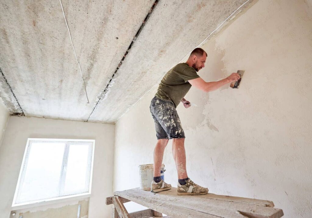 A man repairing damages on drywall